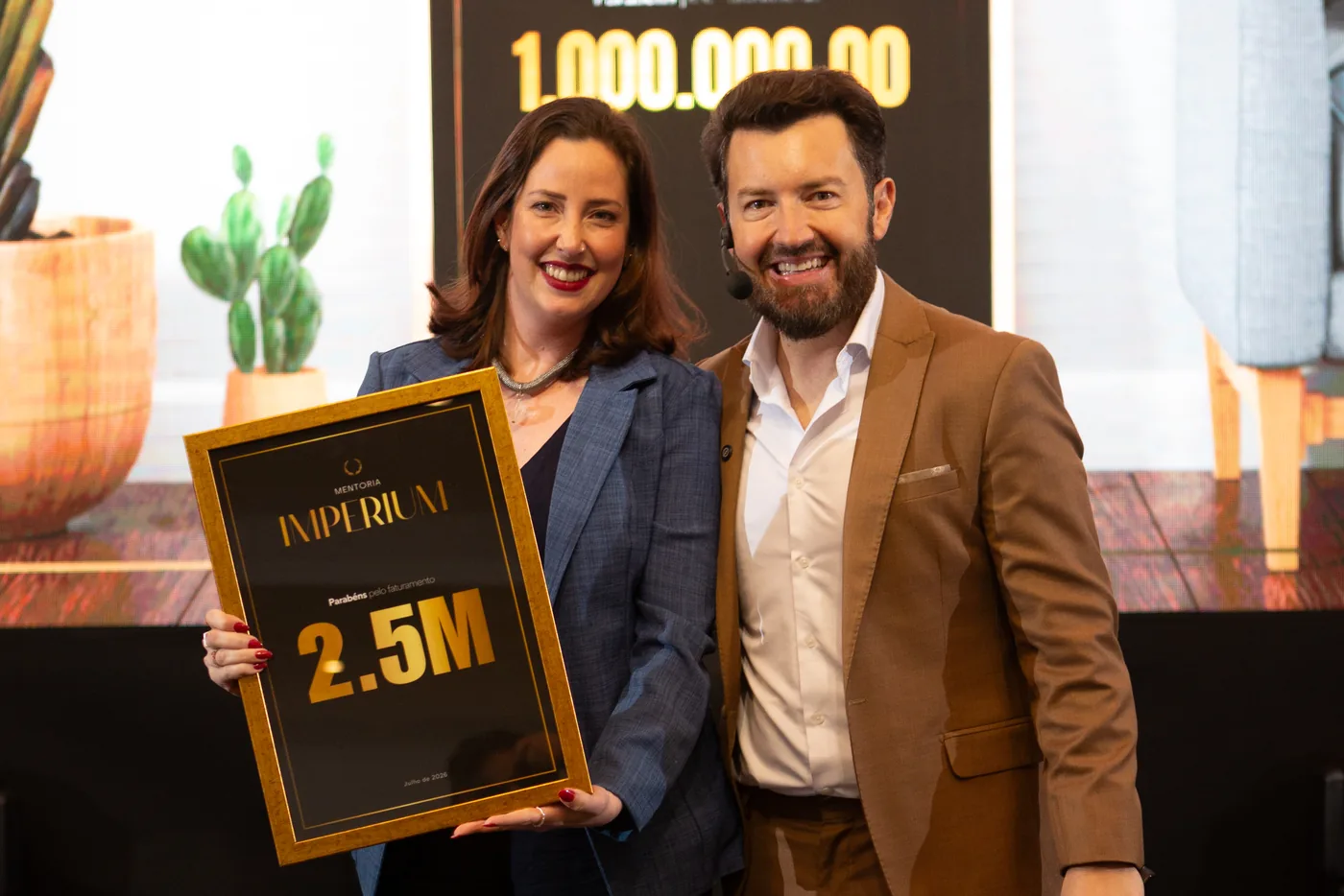 Eduardo Arruda ao lado de participante com a placa de 2,5 milhoes de faturamento