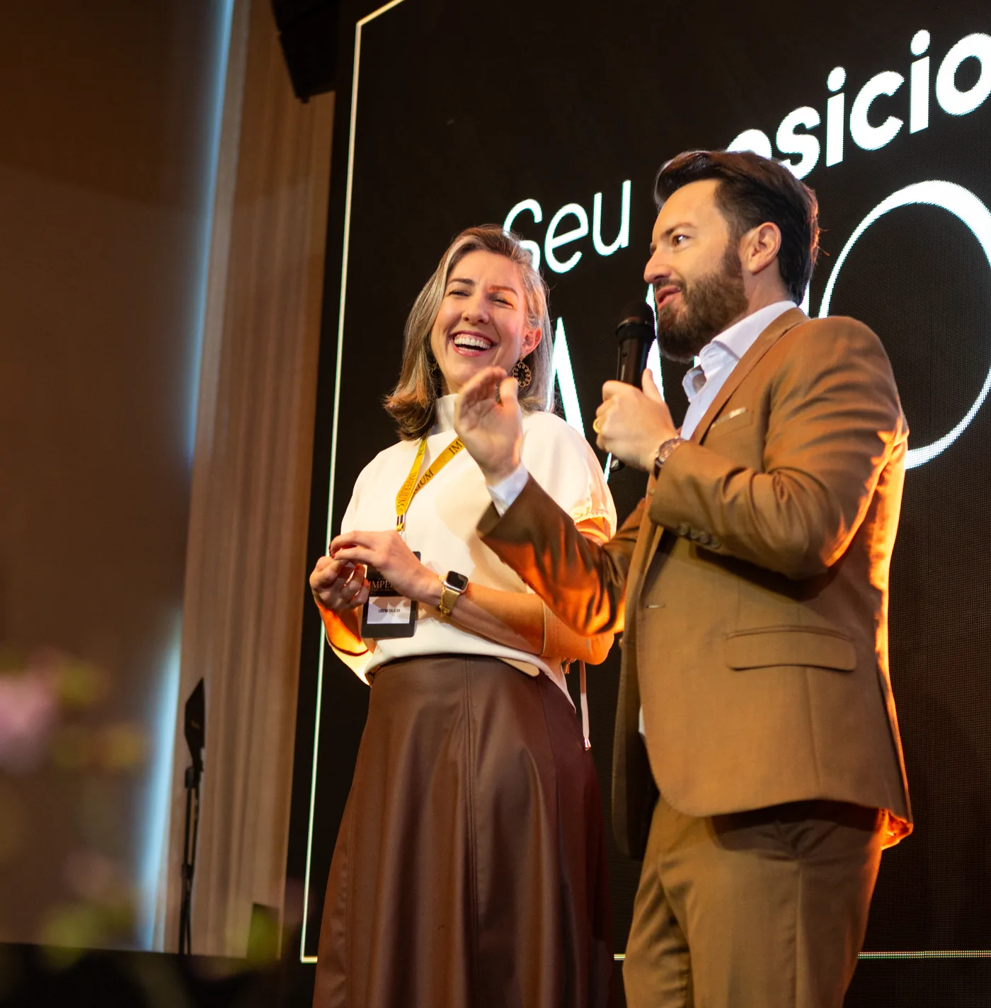 Eduardo Arruda ao lado de uma participante no palco da Imersão Imperium