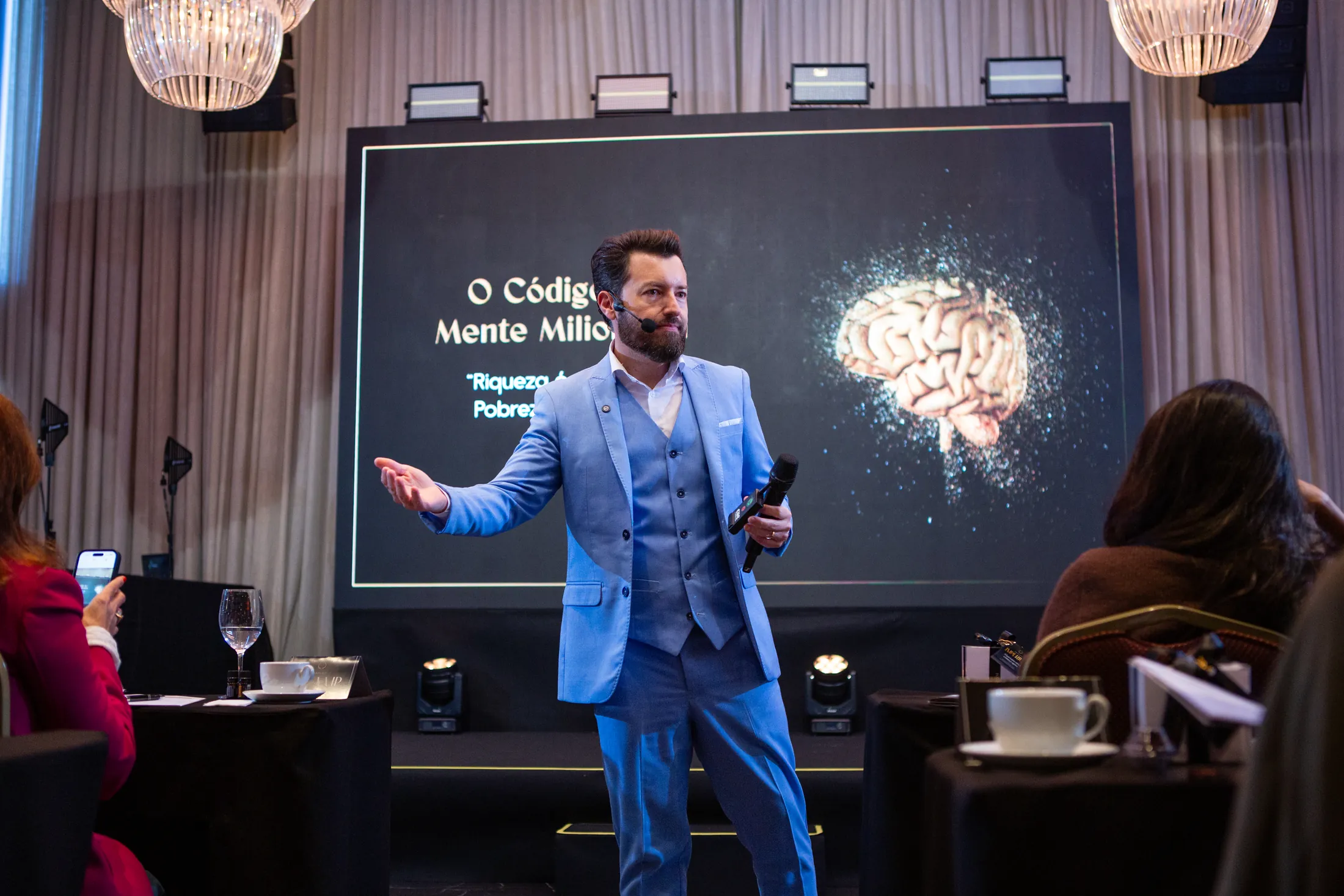 Eduardo Arruda palestrando no palco para uma plateia de empresários