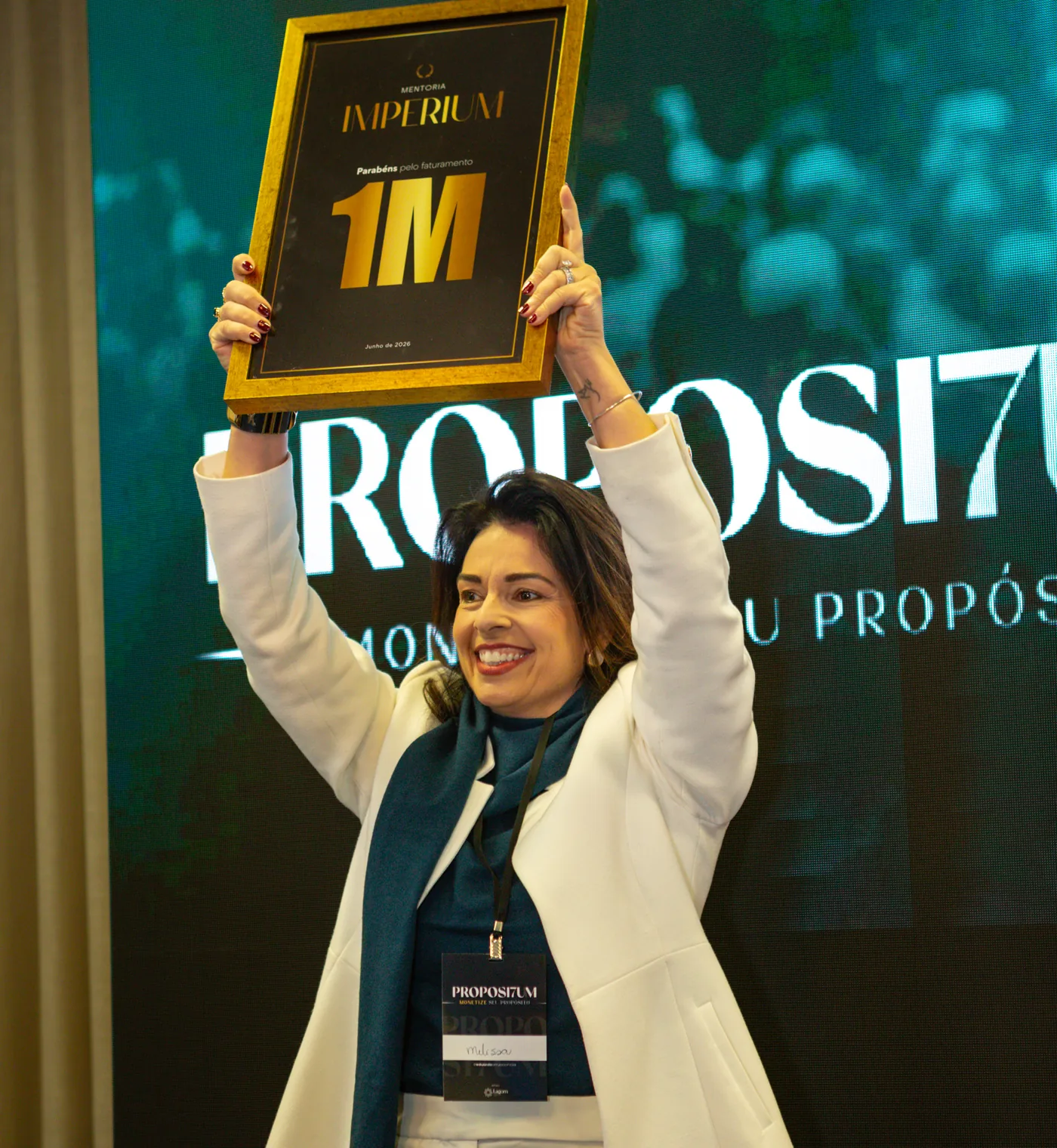 Participante erguendo a placa de um milhão na Imersão Propósi7um